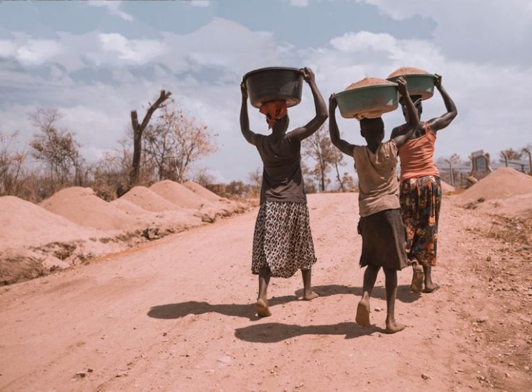 Africa - three women carrying basin while walking barefoot