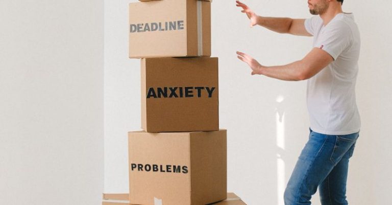 Rent Payments - Man near carton boxes with many different words about stress